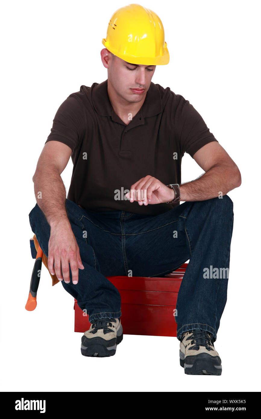 A janitor staring at his watch. Stock Photo