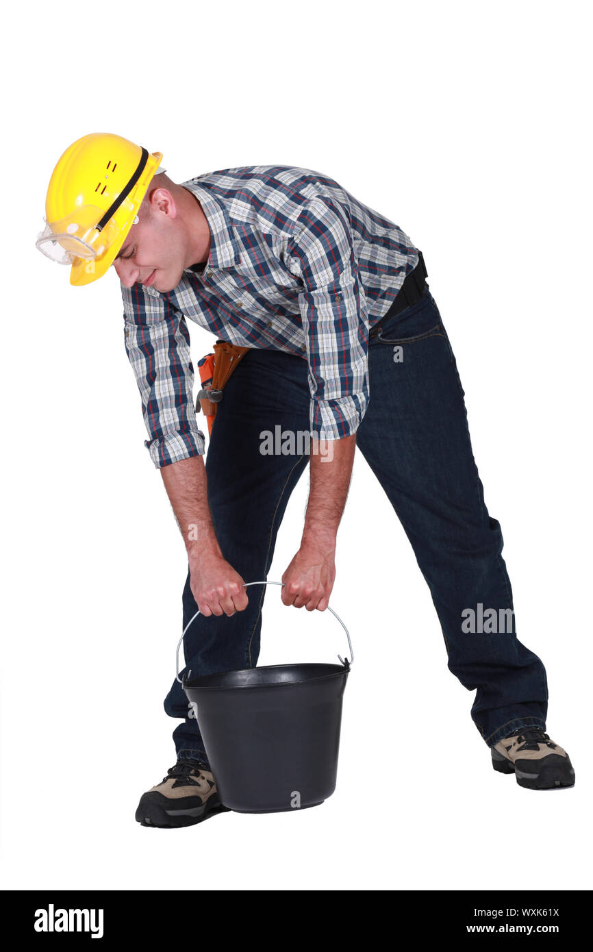 Manual worker trying to lift bucket Stock Photo Alamy