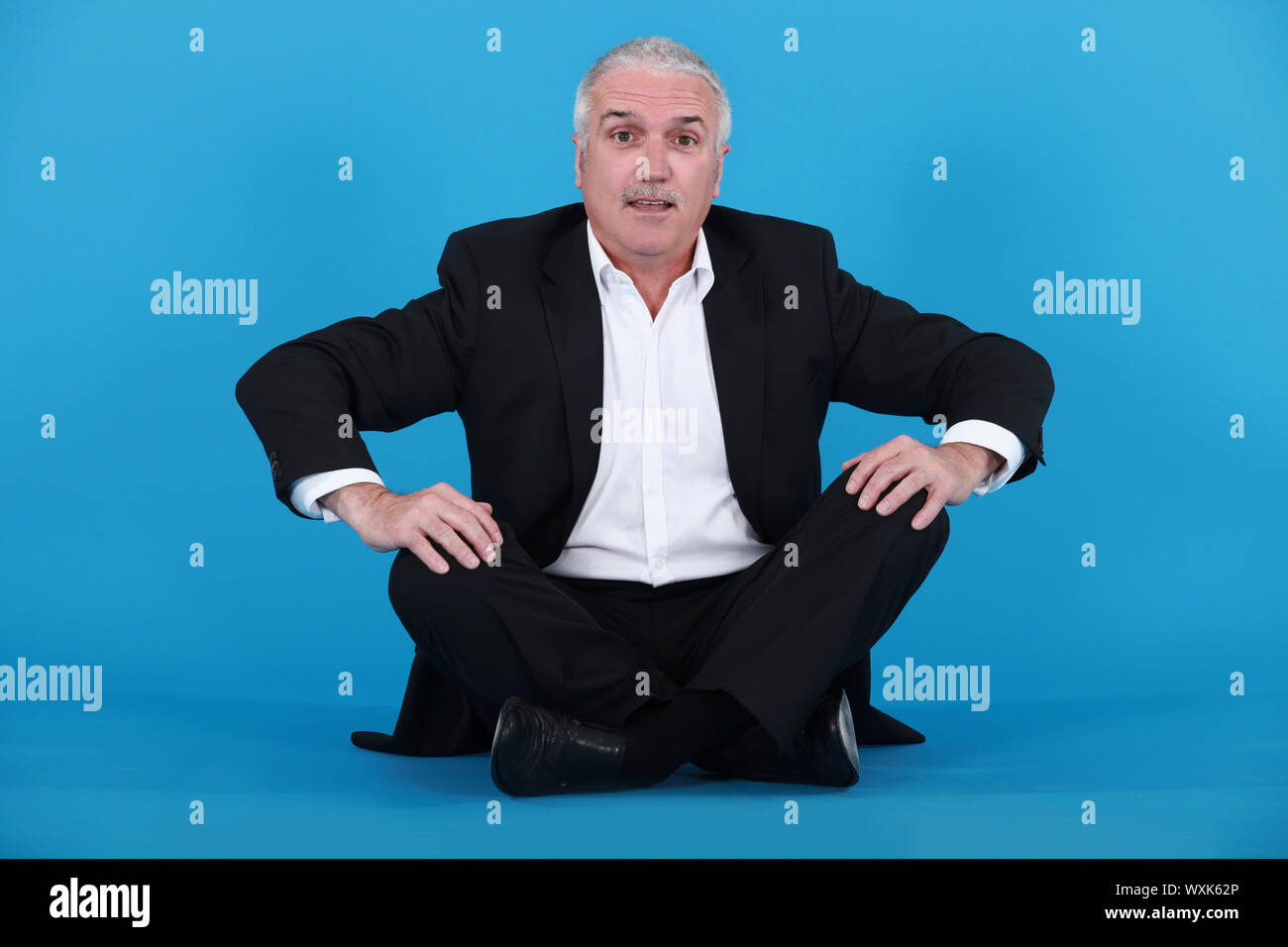 Elderly man sitting on the floor Stock Photo - Alamy