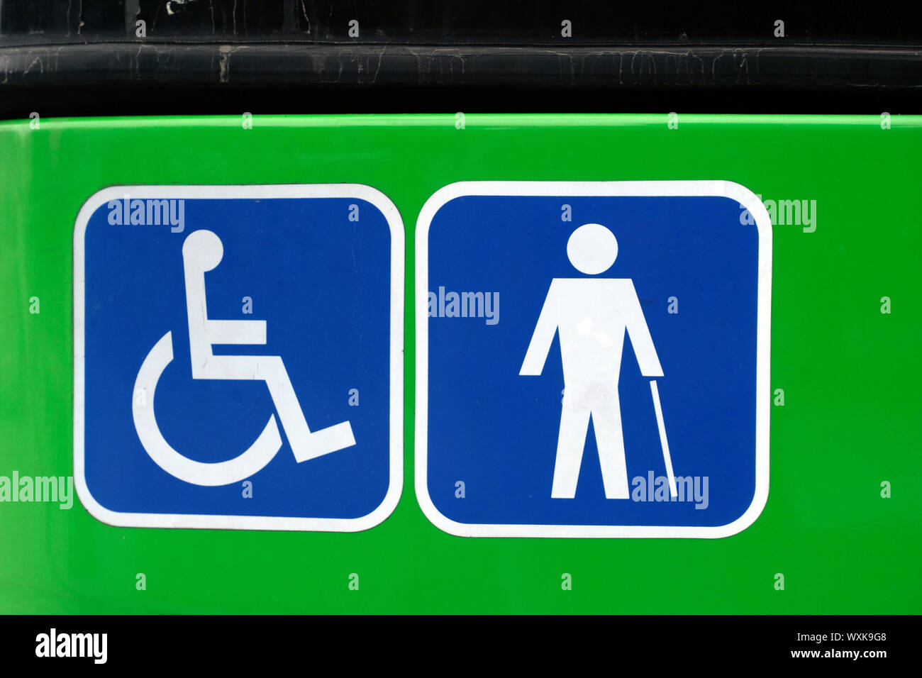 two 'disabled' signs informing the public bus is suitable for people in wheelchairs and provides accessibility for blind people Stock Photo