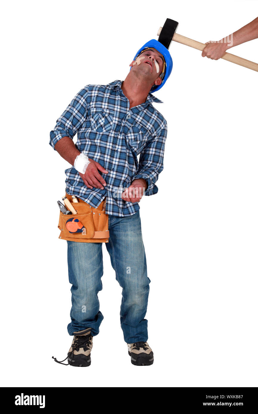Builder being hit over the head by hammer Stock Photo Alamy
