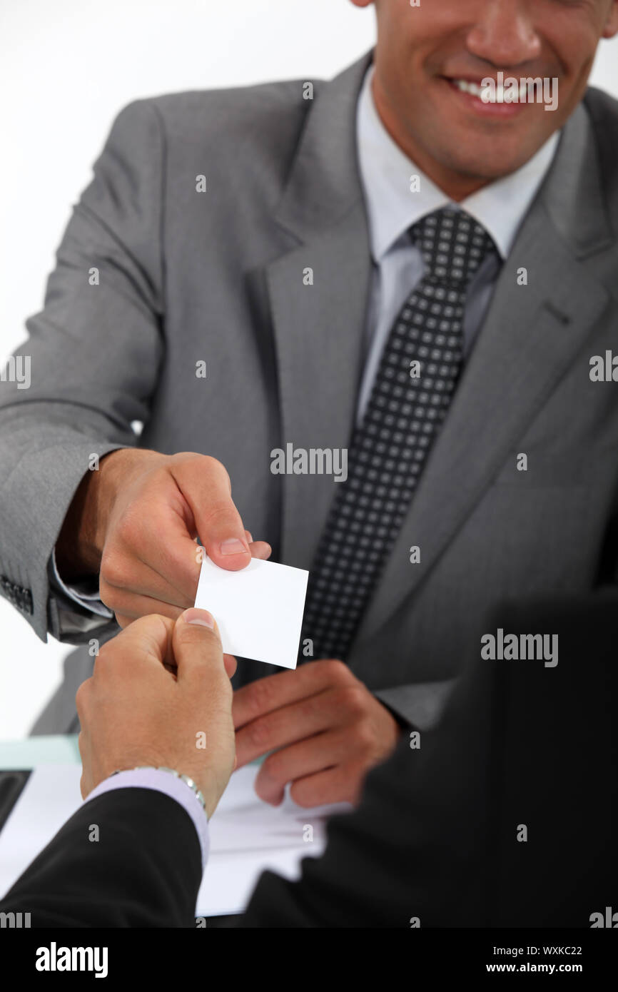 Businessman handing over his business card to a potential client Stock Photo