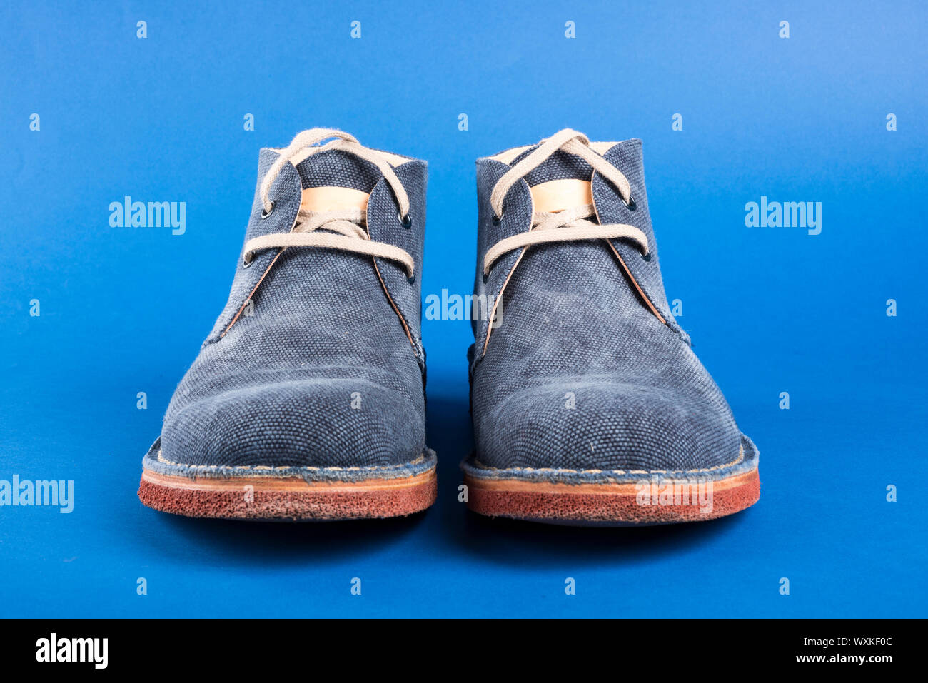 Men's denim shoe on a blue background Stock Photo - Alamy