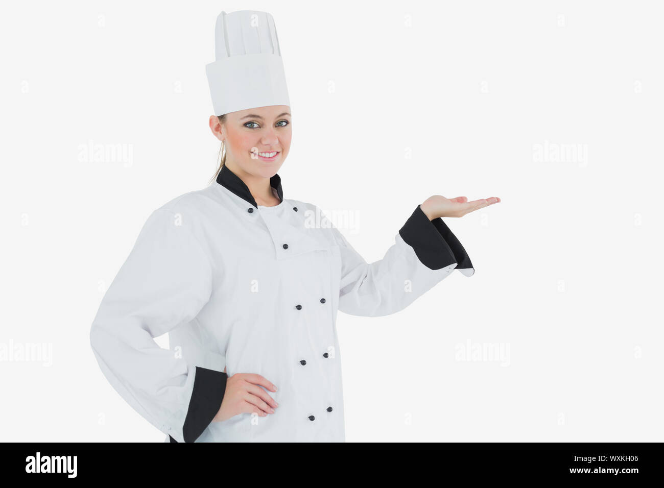 Portrait of female chef holding out your product against white ...