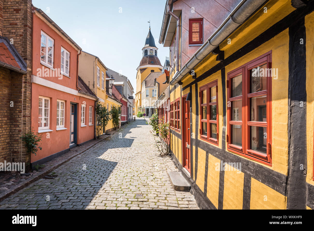 An alleyway with cobblestones and half timbered houses, leading up to the church in Faaborg, Denmark, July 12, 2019 Stock Photo