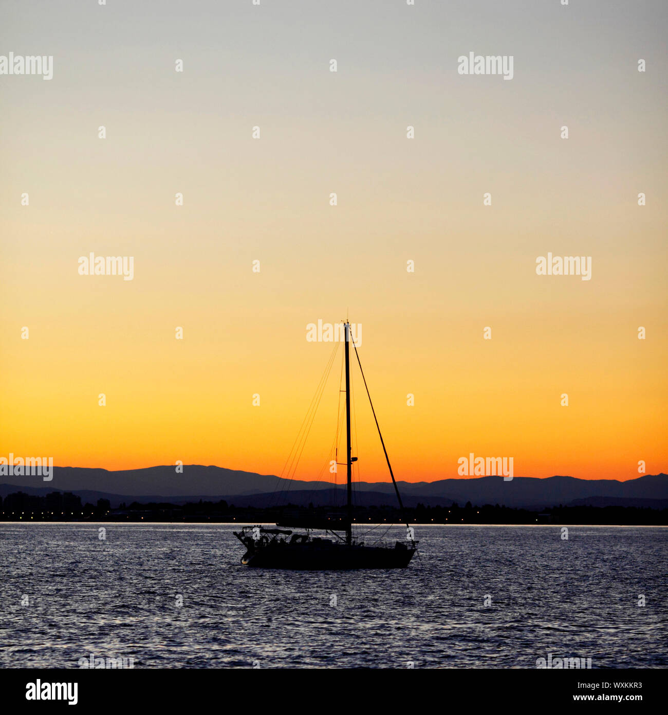 Silhouette of a yacht in the sea at sunset Stock Photo - Alamy