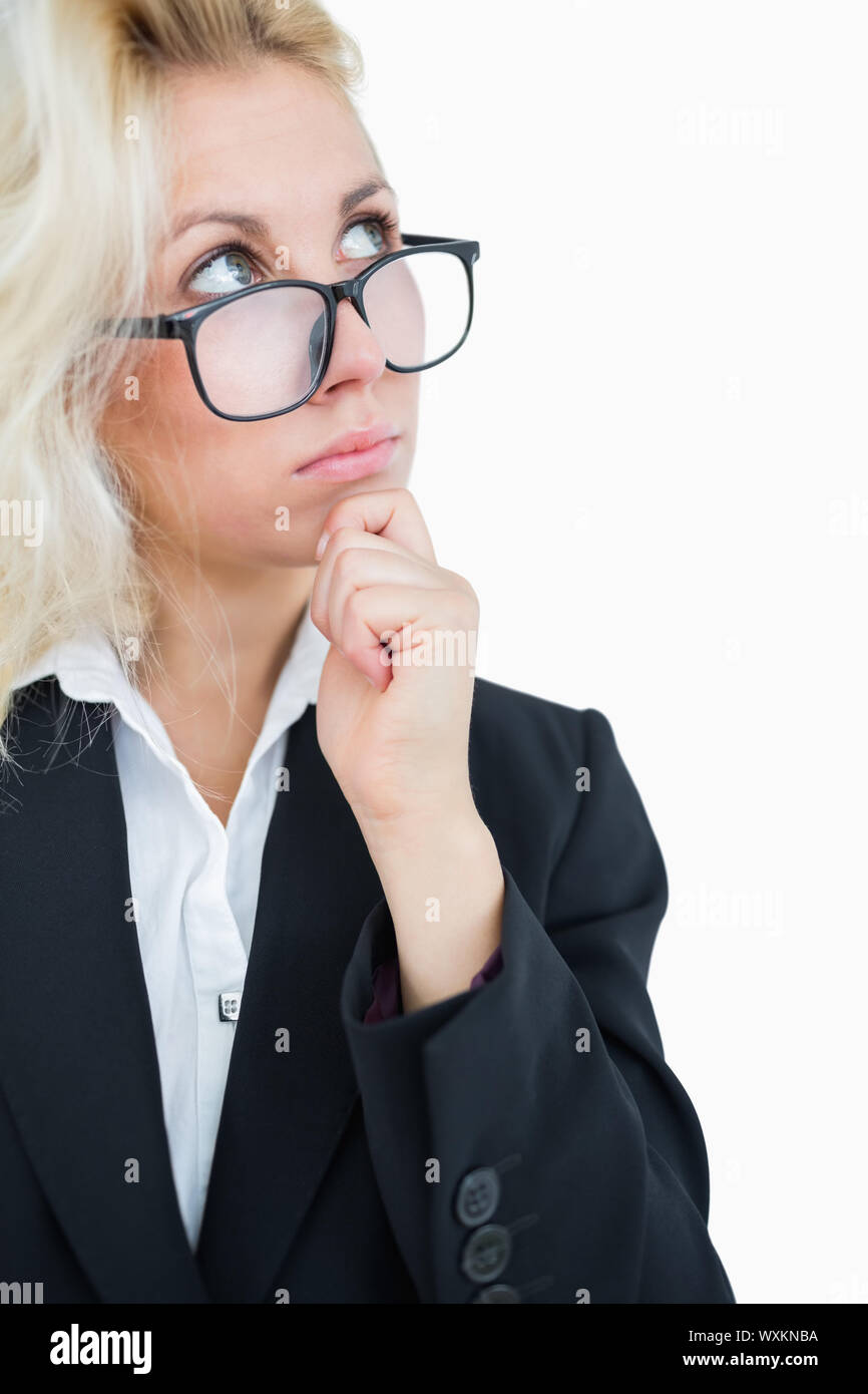 Thoughtful young business woman looking up with hand on chin over white ...
