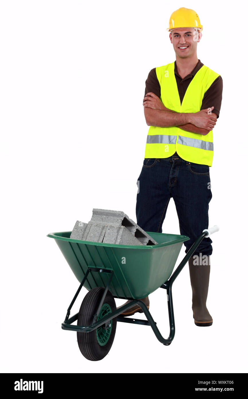 Happy construction worker with wheelbarrow Stock Photo - Alamy