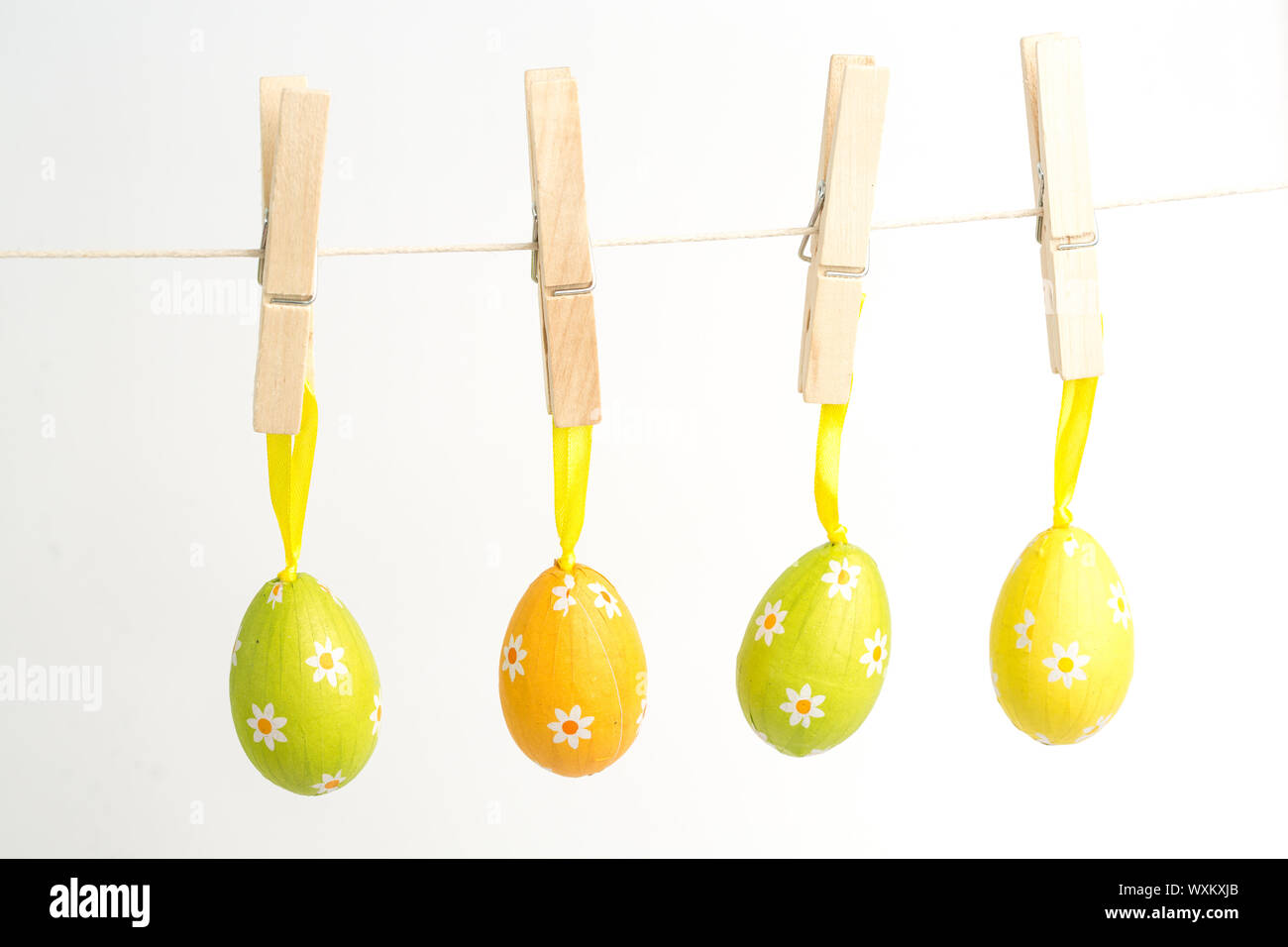 Four easter eggs hanging from a line from wooden pegs Stock Photo