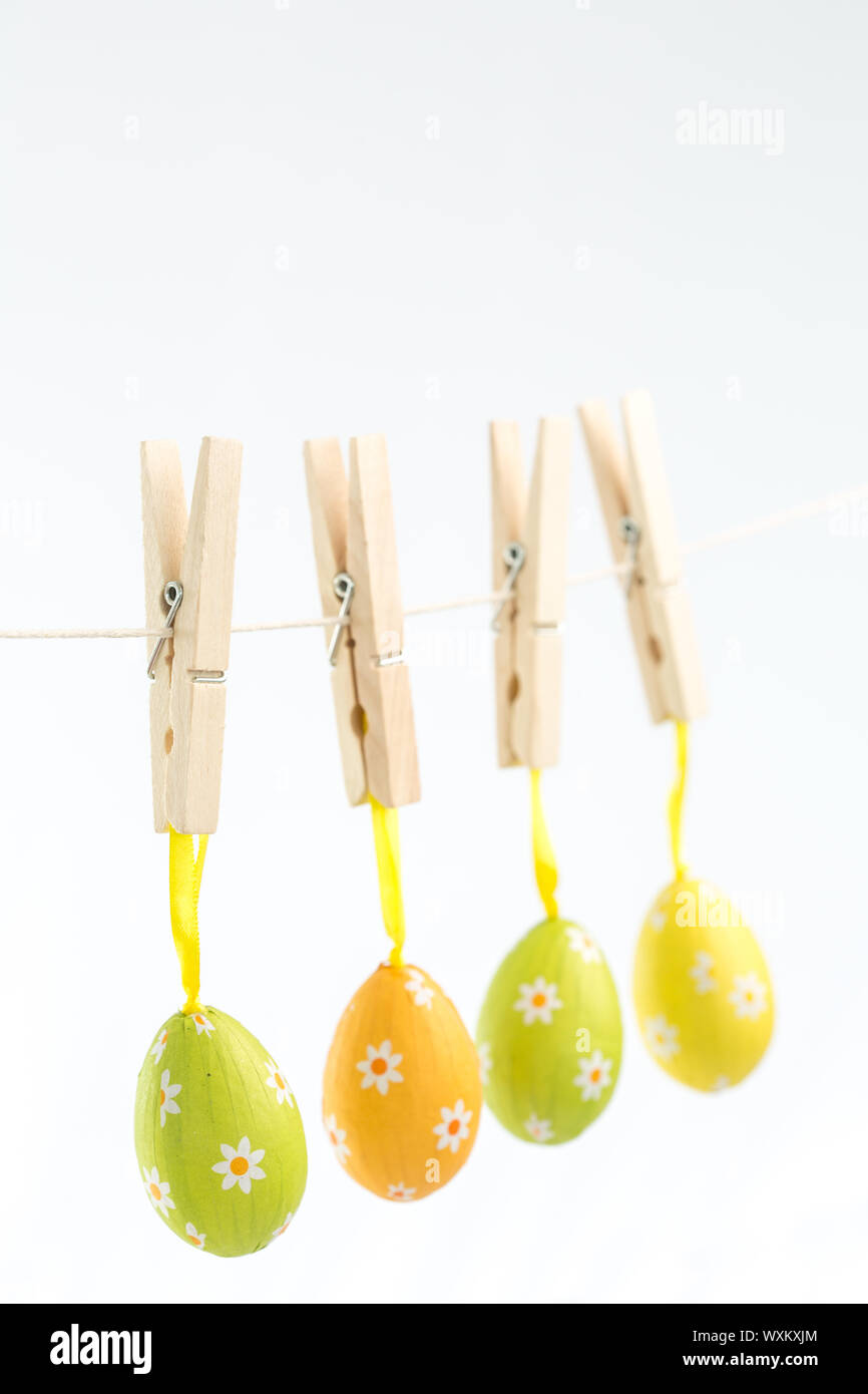 Easter eggs hanging from a line on white background Stock Photo
