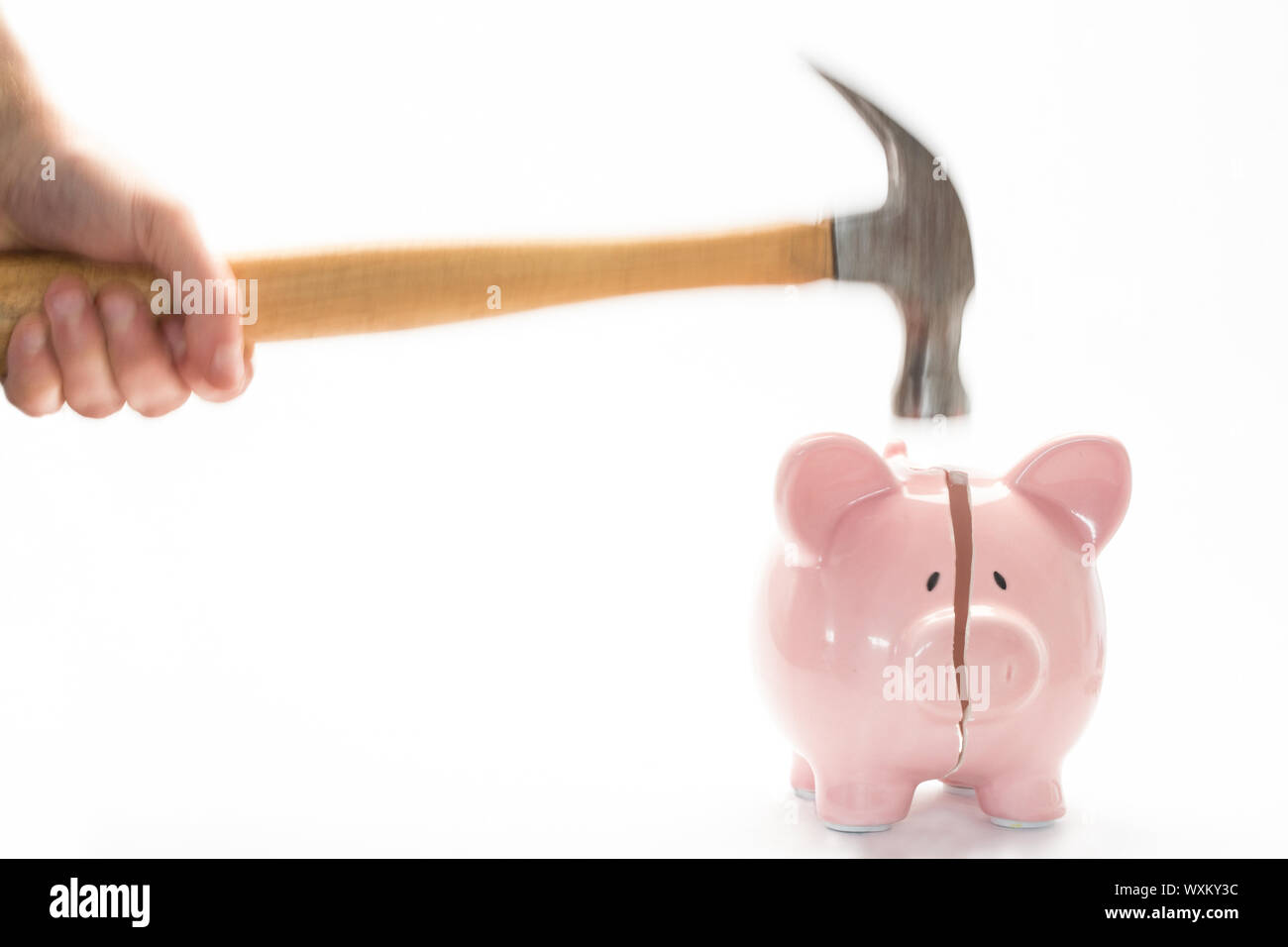 Hammer breaking piggy bank on white background Stock Photo - Alamy