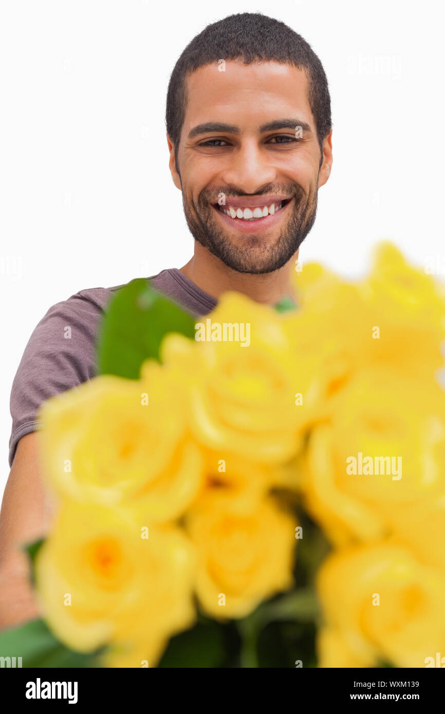Handsome man offering bunch of yellow roses on white background Stock Photo Alamy