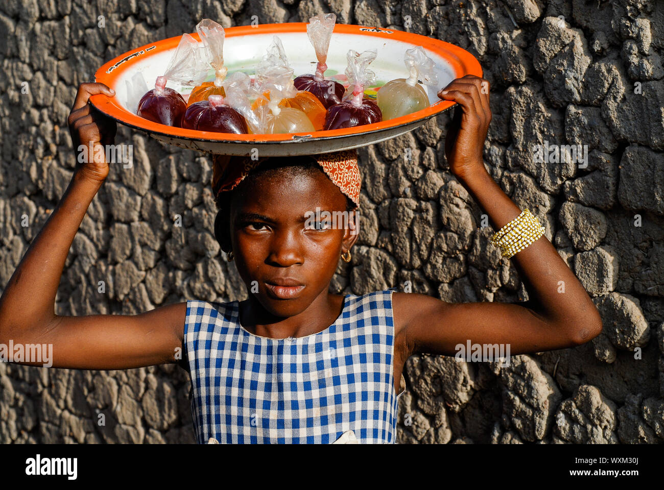 MALI, village Faragouaran , girl sells lemonade in plastic bags on the market / Markt im Dorf Faragouaran, Maedchen verkauft Lemonade in Plastiktueten auf dem Markt um Einkommen zu erzielen Stock Photo