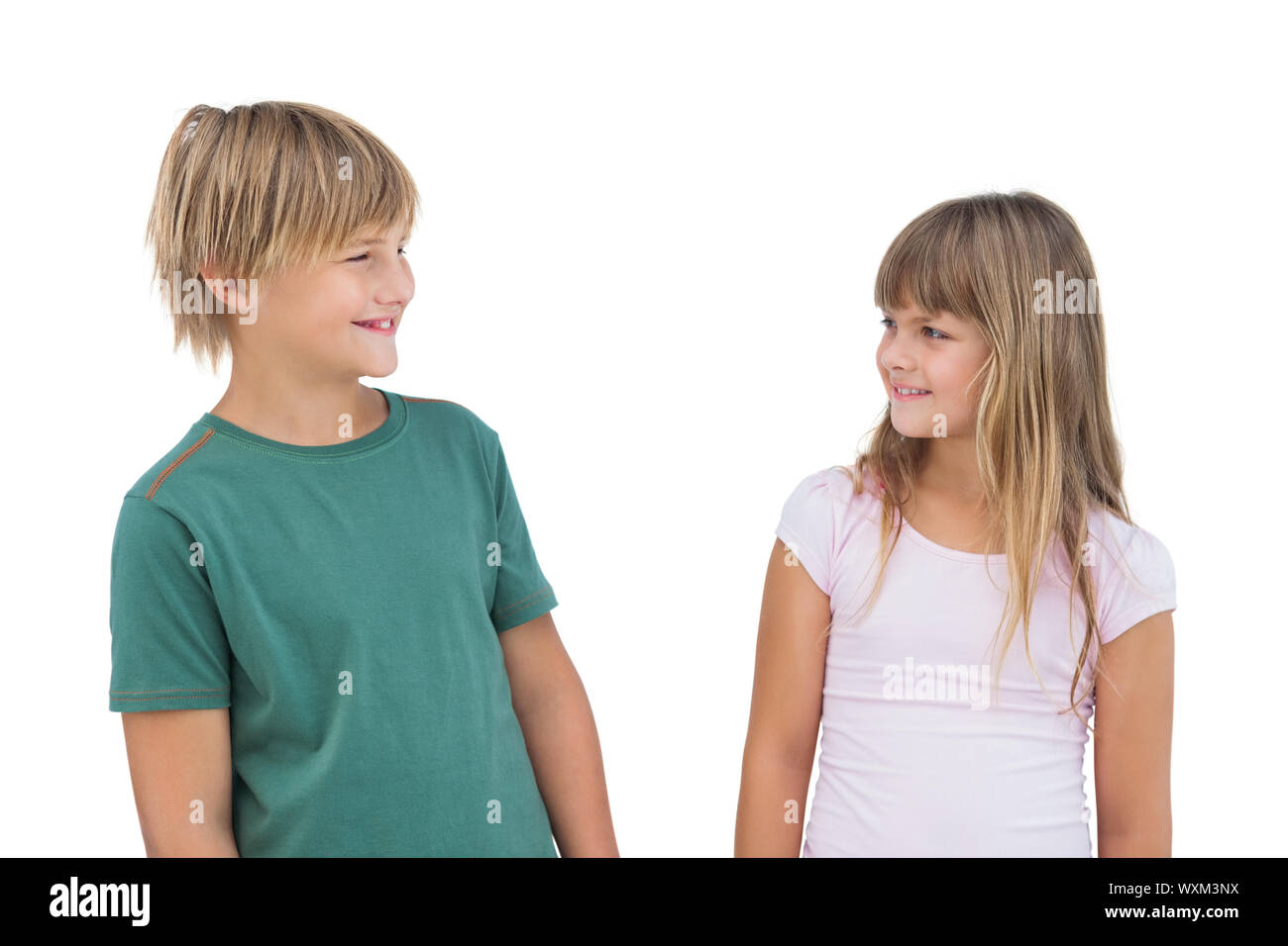 Little girl and boy looking at each other and smiling on white background Stock Photo Alamy