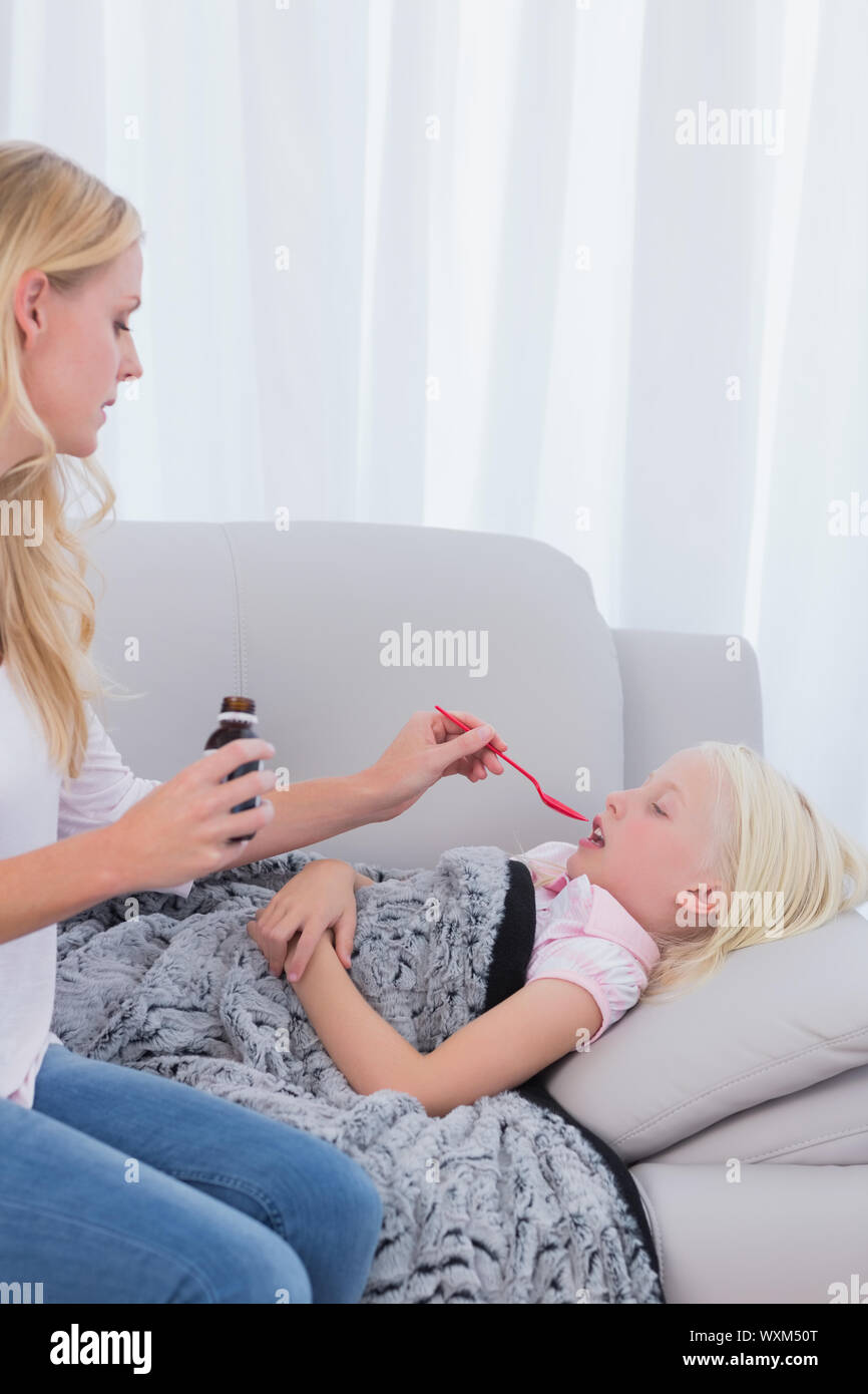 Mother giving her sick daughter cough medicine Stock Photo Alamy