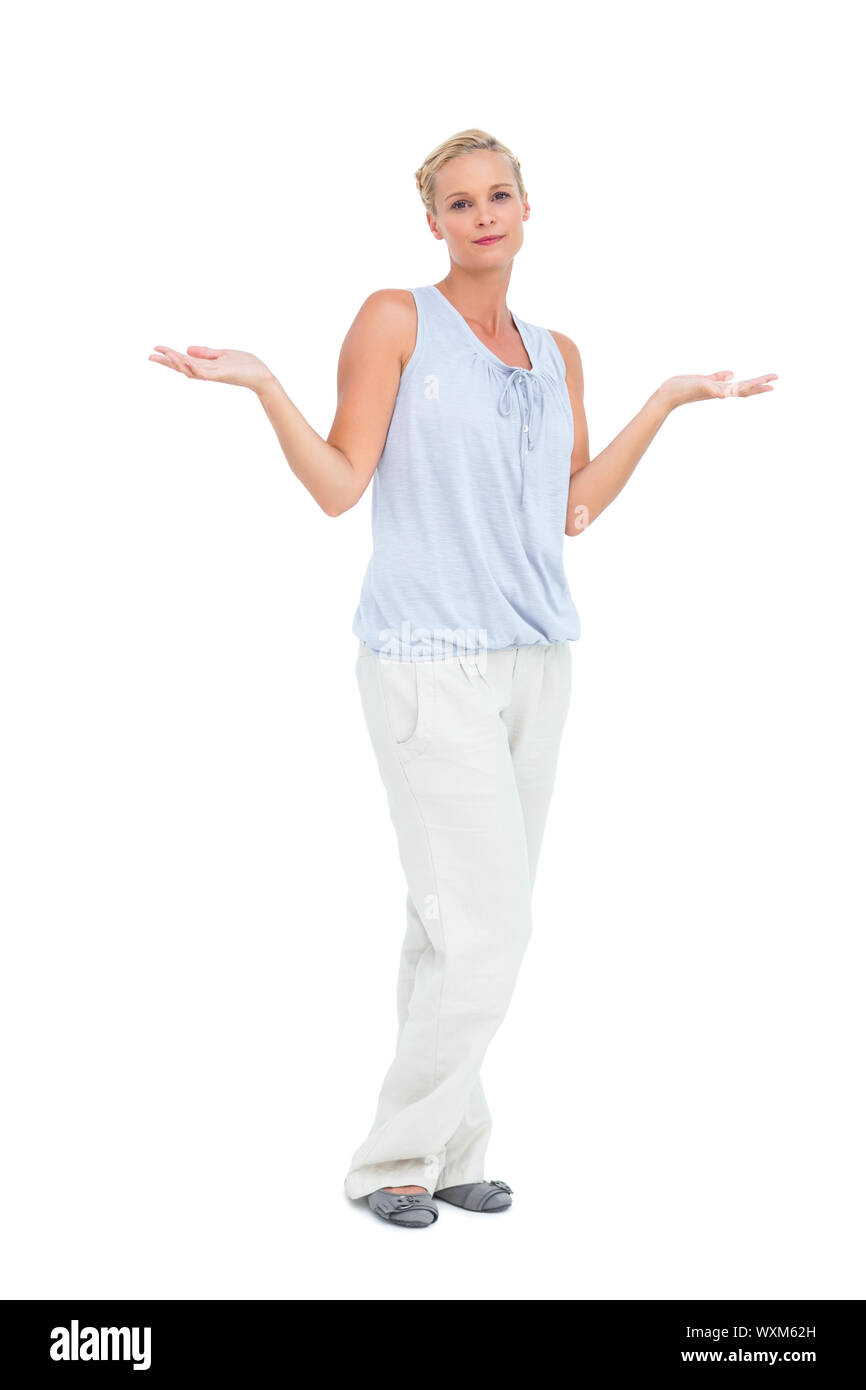 Blonde woman with arms raised in question looking at camera on white ...