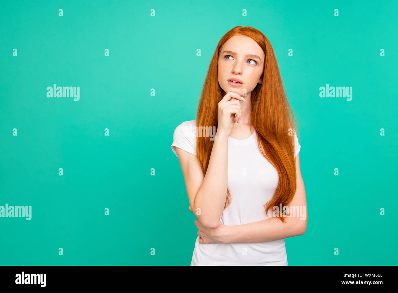 Photo of confused person with long hair, stand in white t-shirt Stock Photo