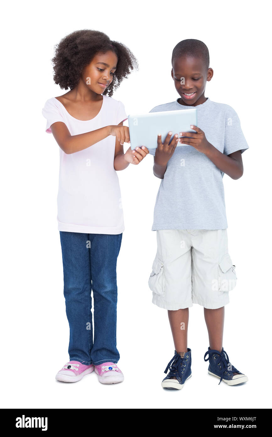 Brother and sister using tablet pc on a white background Stock Photo