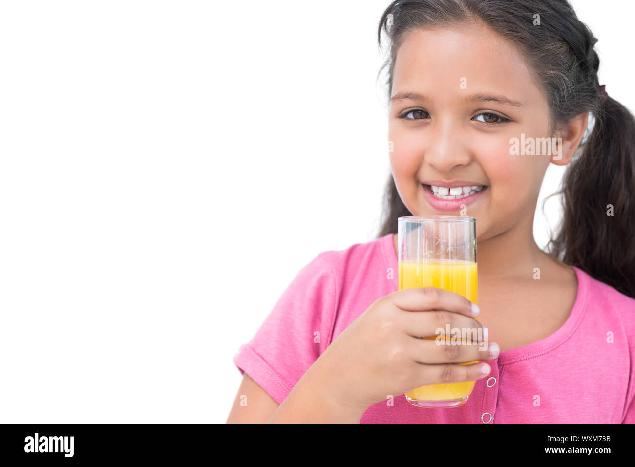 Cheerful little girl drinking orange juice on white background Stock ...
