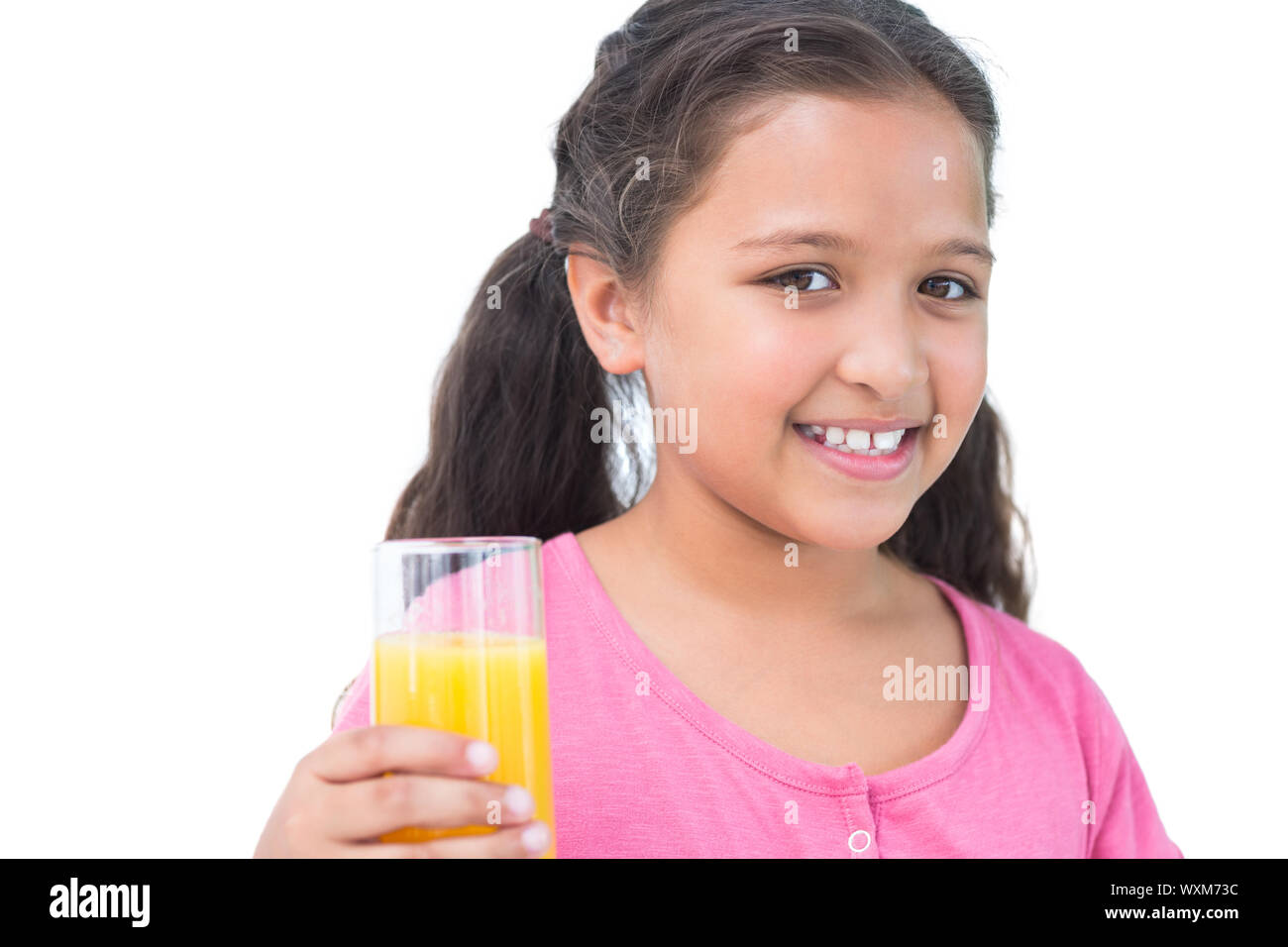 Little girl drinking orange juice on white background Stock Photo - Alamy