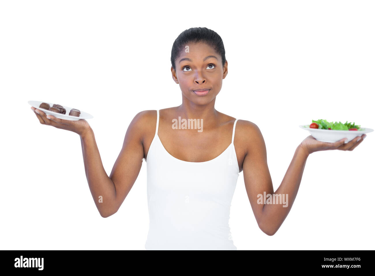 Conflicted woman deciding to eat healthily or not on white background Stock Photo