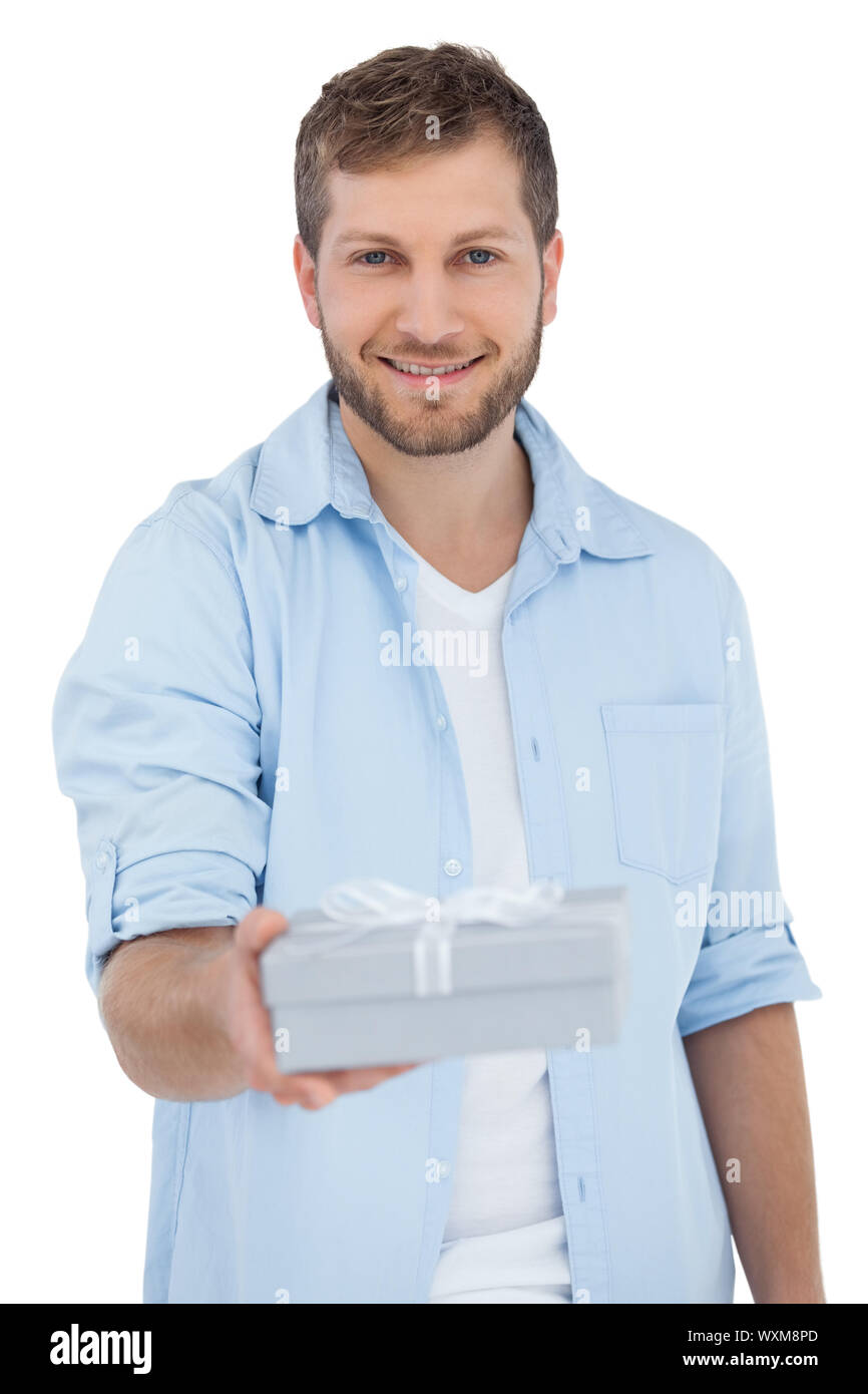 Guy Offering Happy man offering a gift looking at camera on white background Stock ...