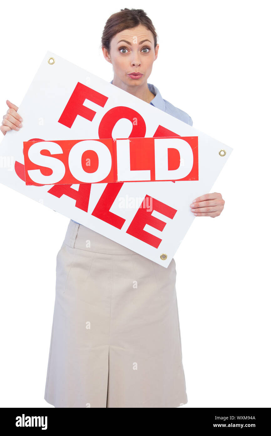 Estate agent showing for sale sign with sold sticker across it against white background Stock Photo