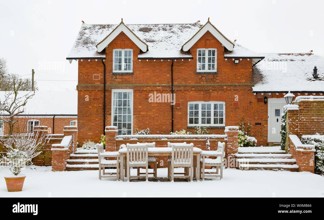 Heritage home and gardens covered in snow in winter, England, UK Stock Photo