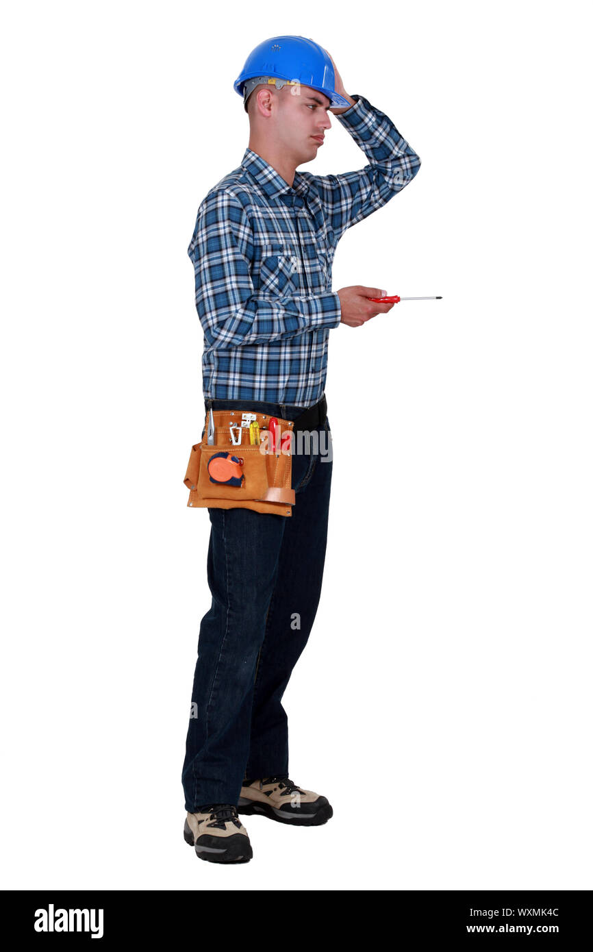 Annoyed tradesman performing a tedious task Stock Photo