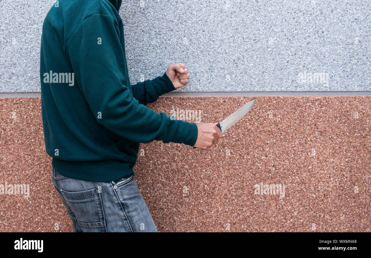 Man, teenager holding large knife. Gang crime, youth crime... concept