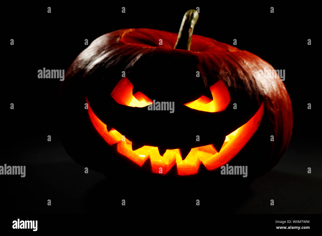 Halloween pumpkin with scary face on black background Stock Photo - Alamy