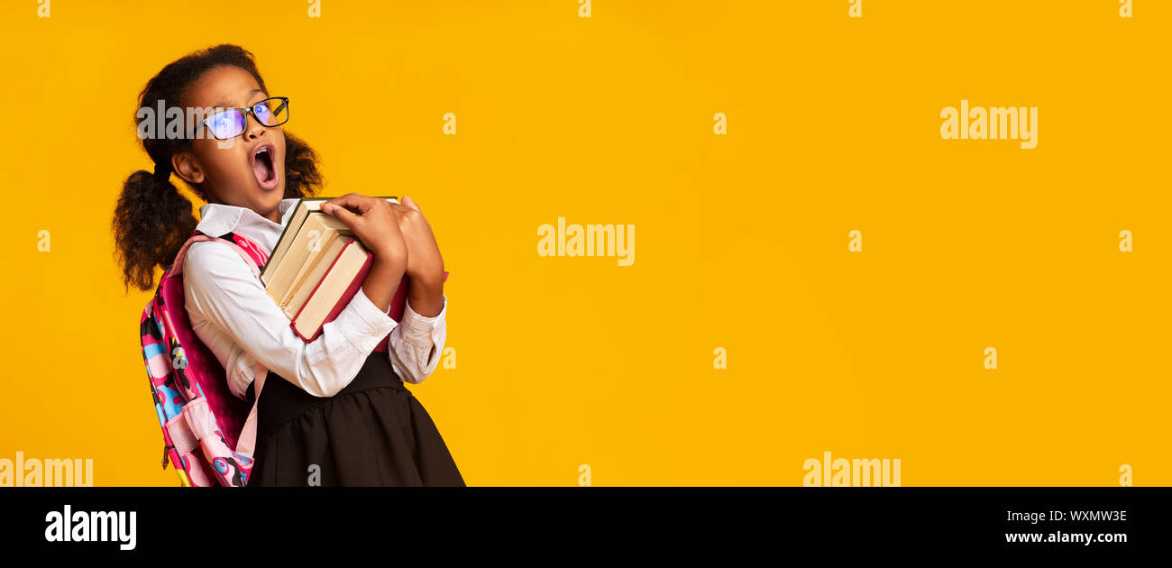 Afro Elementary Student Girl Yawning Holding Books, Yellow Background, Panorama Stock Photo