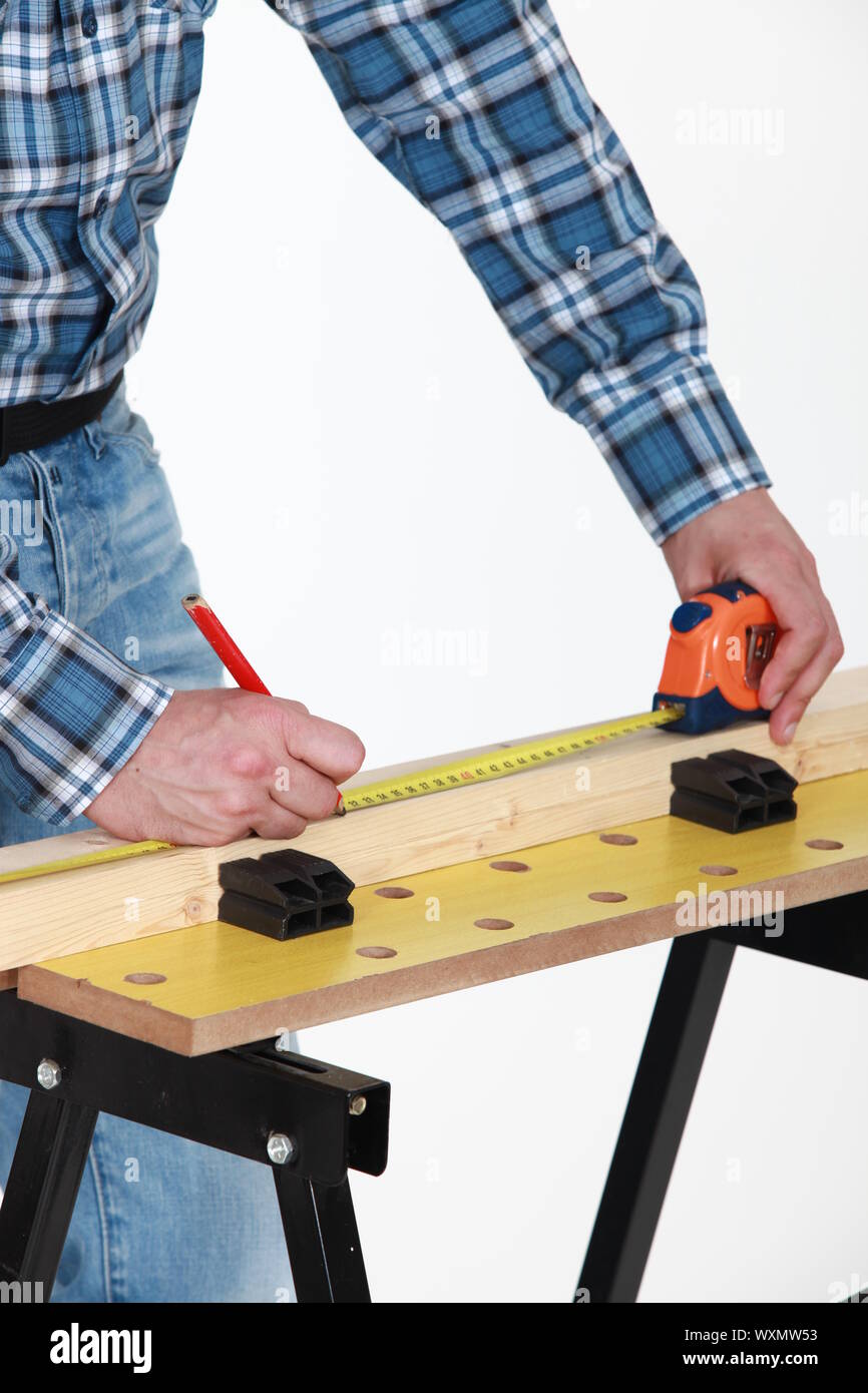 Carpenter measuring a plank Stock Photo