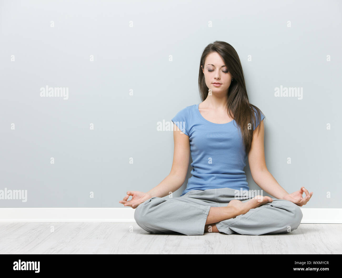 Young woman in the lotus position while meditating Stock Photo - Alamy