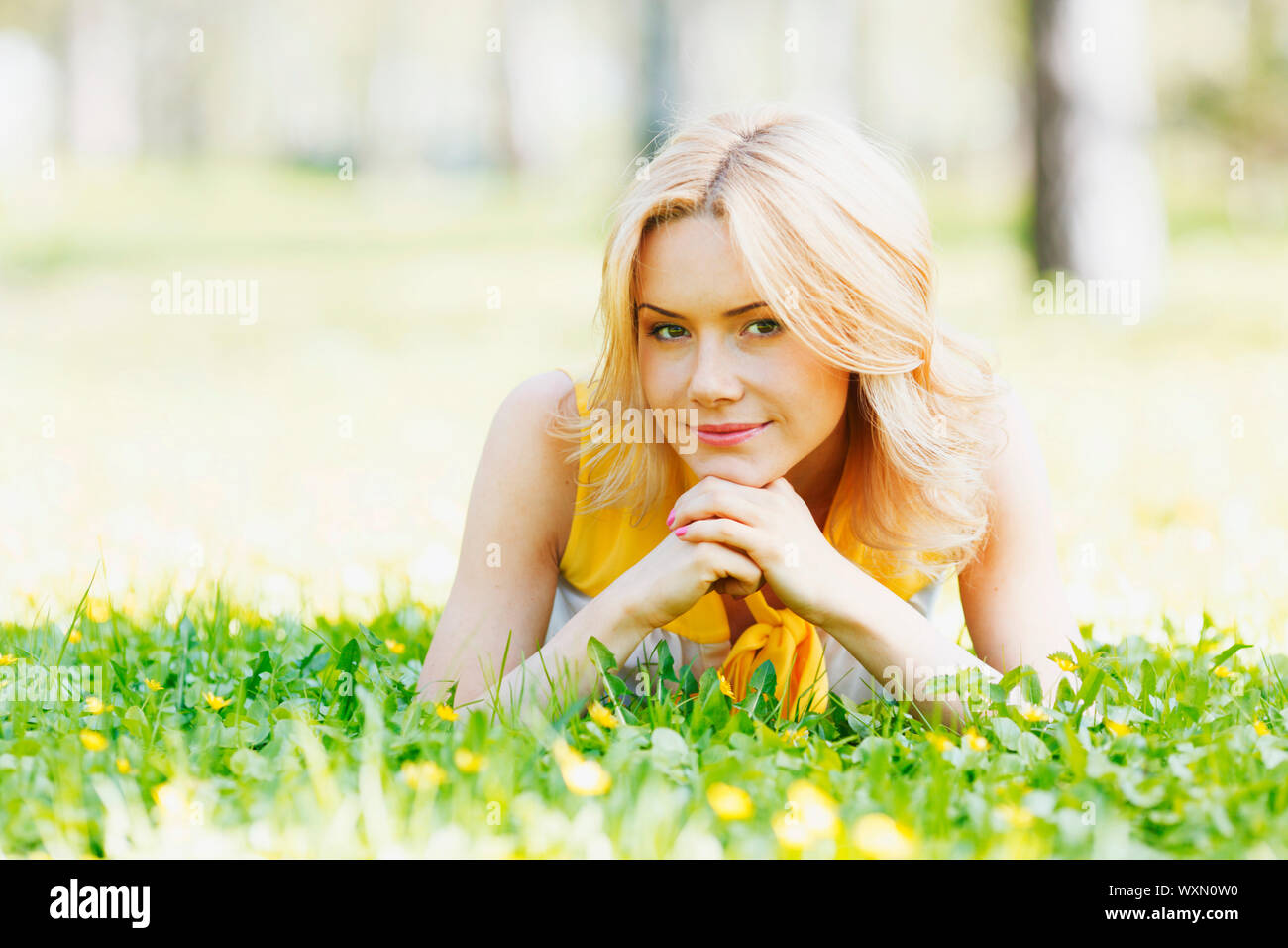Happy young woman lying on grass Stock Photo - Alamy