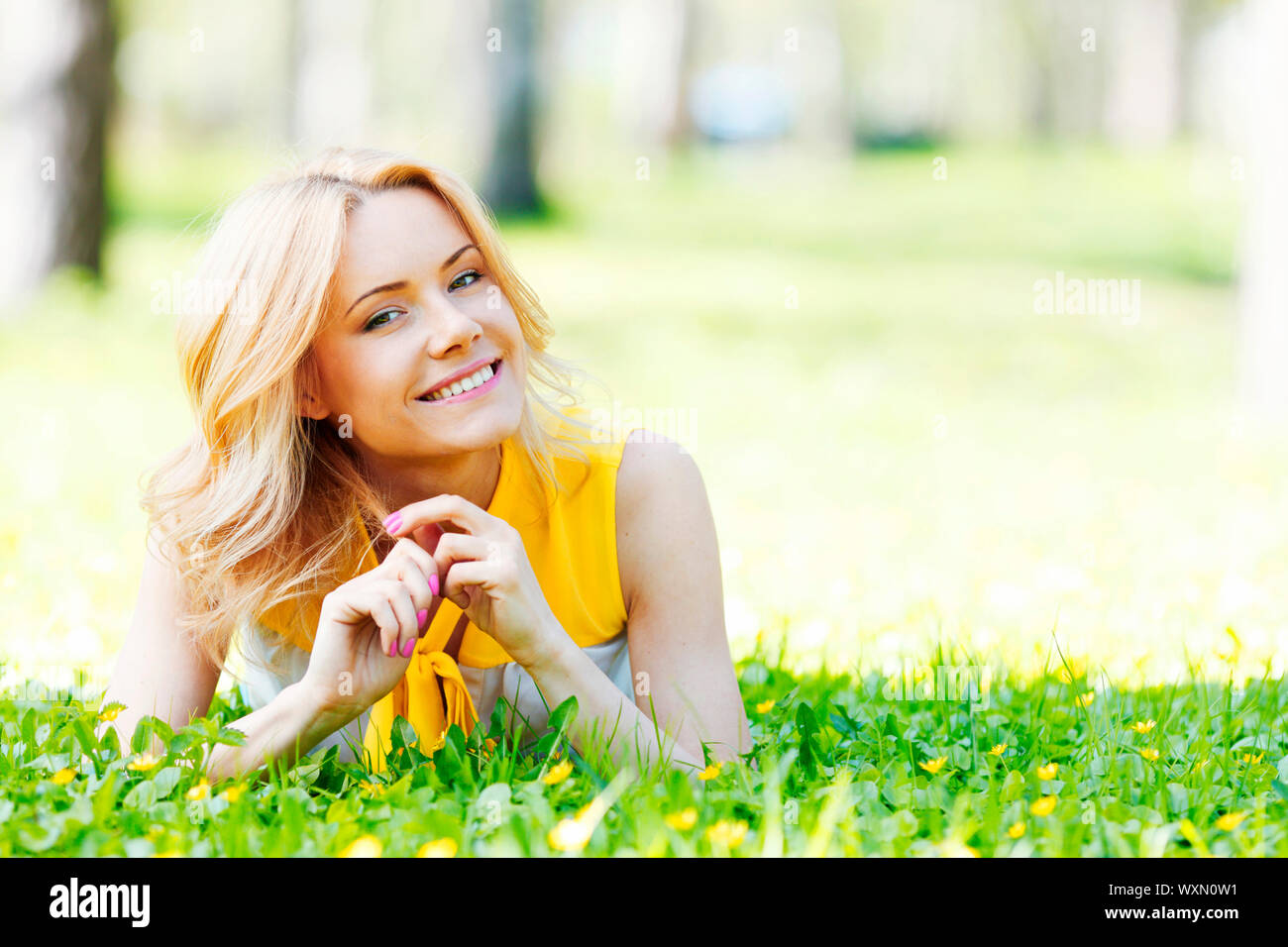 Happy young woman lying on grass Stock Photo - Alamy