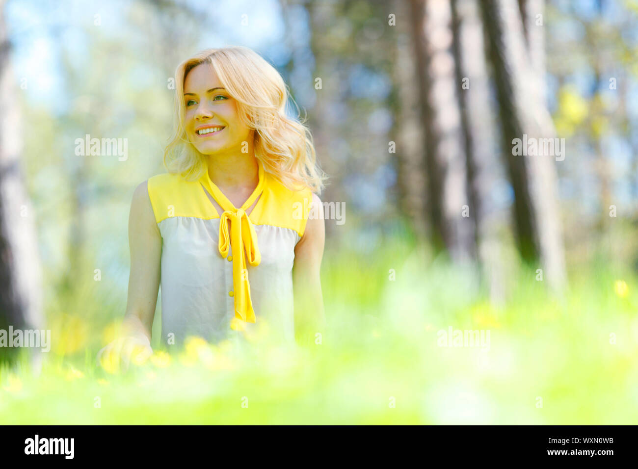 Beautiful happy young woman sitting on grass Stock Photo - Alamy