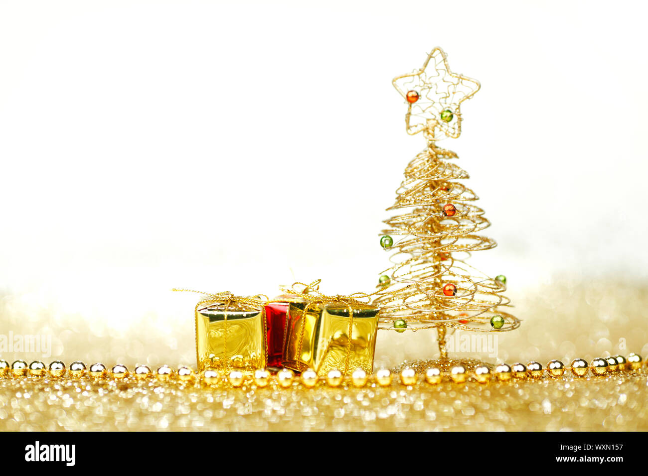 Golden christmas fir tree decoration and gifts on glitter background ...