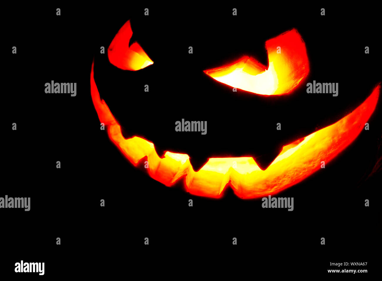Halloween pumpkin with scary face on black background Stock Photo - Alamy