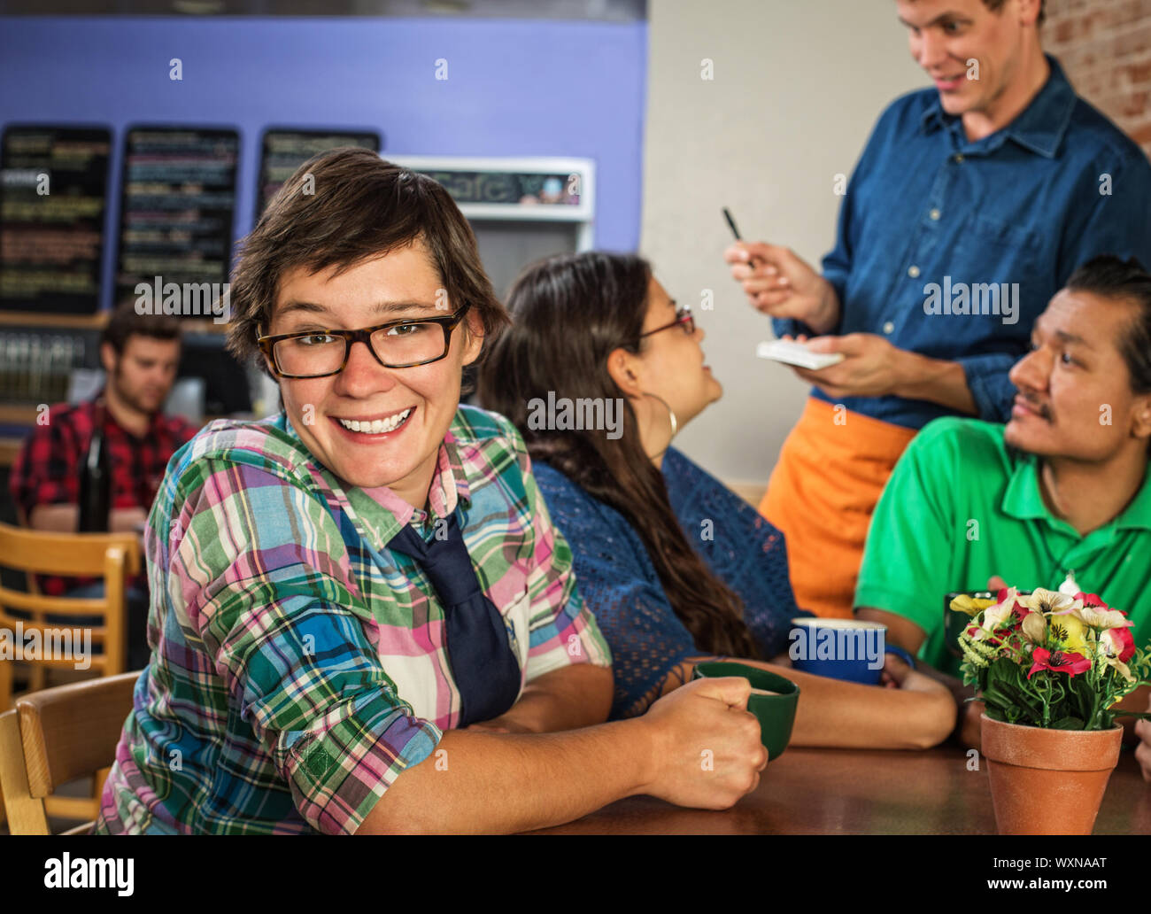 Cheerful young white female with friends in coffee house Stock Photo