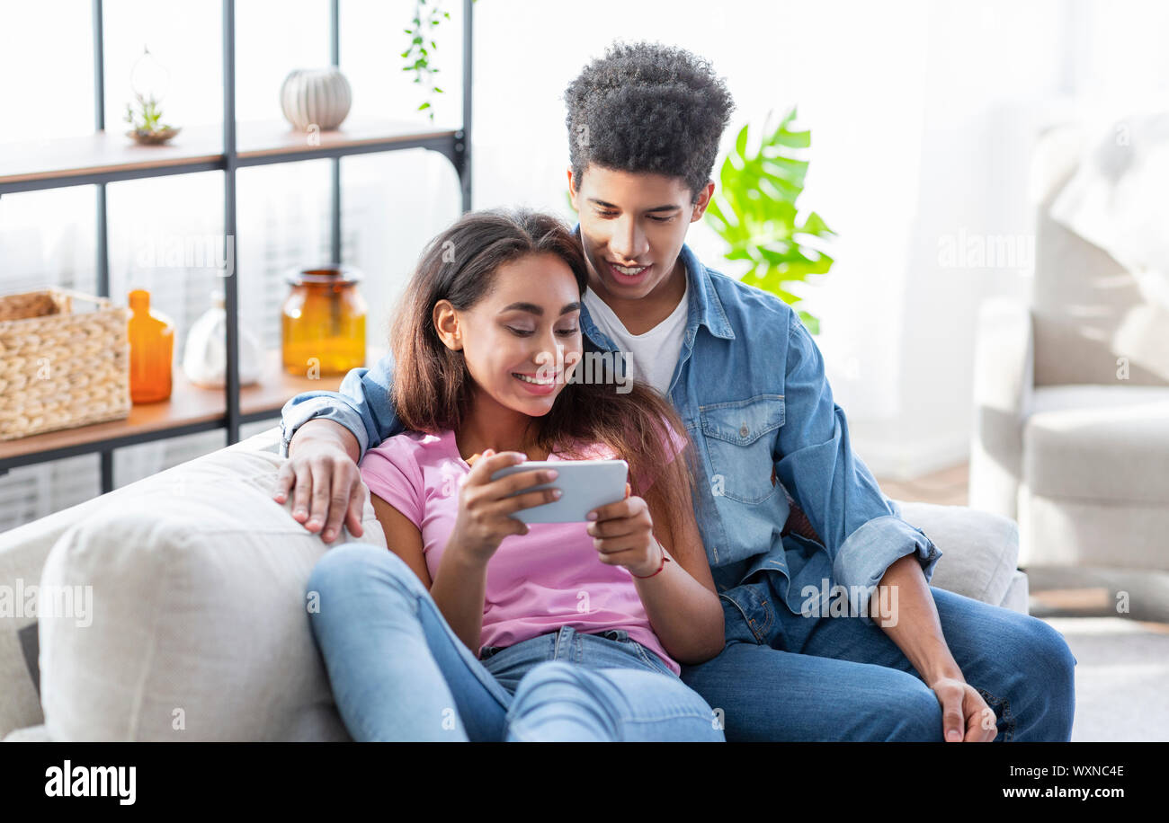 Couple of teenagers watching videos online on smartphone Stock Photo