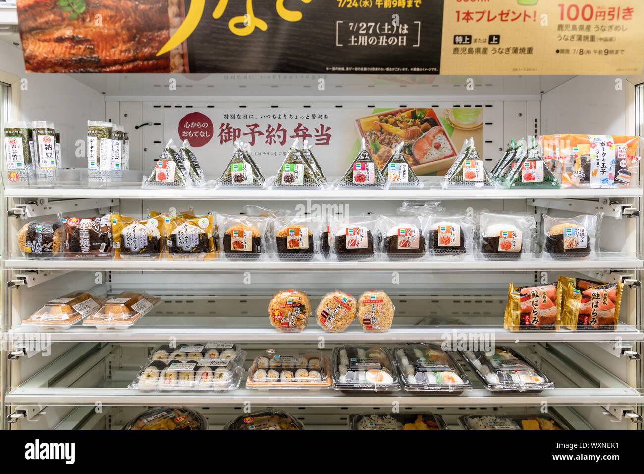Colorful onigiri rice balls and bento boxes displayed at a convenience store shelf