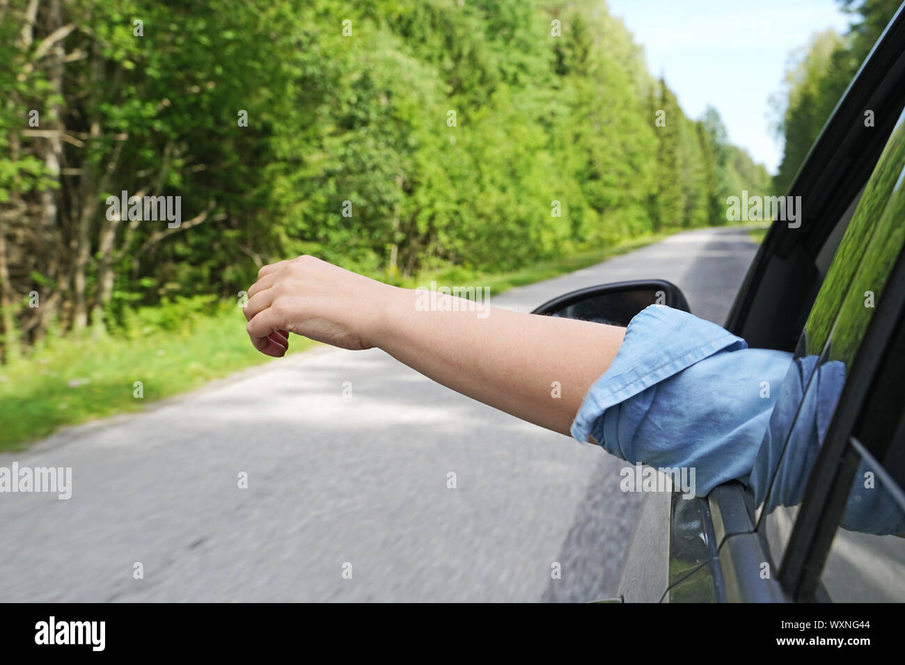 Woman's hand outside car window. Summer vacations concept. Stock Photo