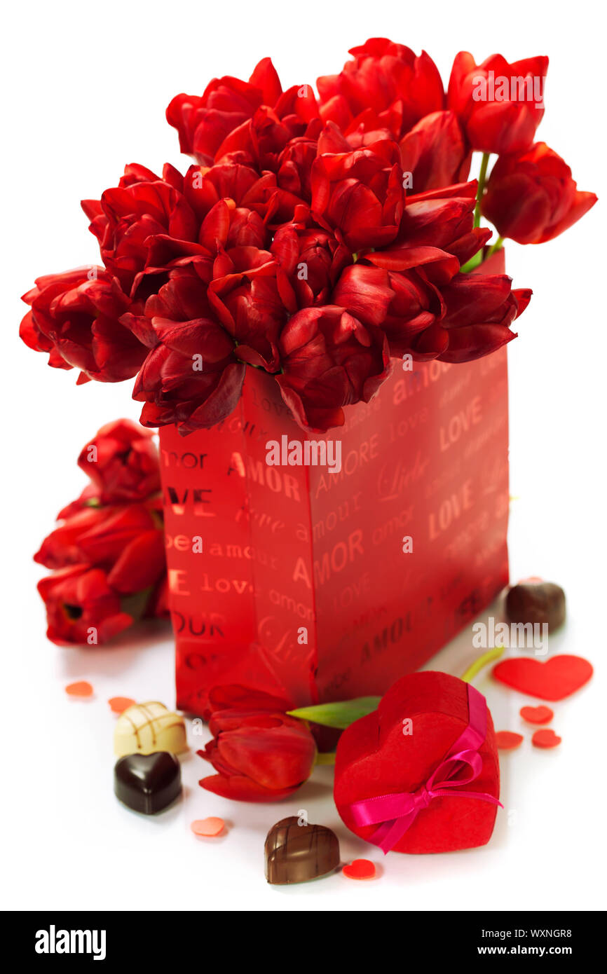 Valentine composition with shopping bag, gift box, chocolate and fresh tulips over white Stock Photo