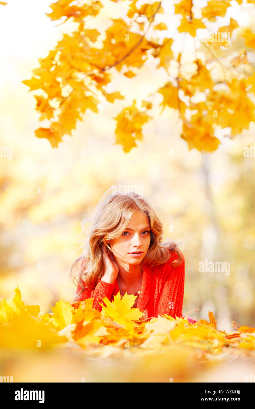 Happy young woman laying on autumn leaves in park Stock Photo - Alamy