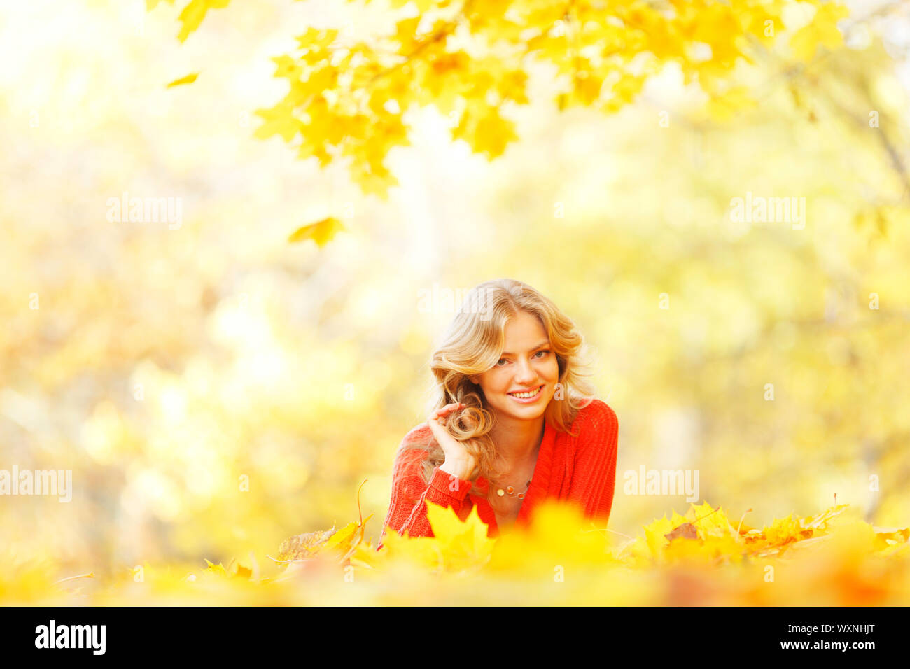 Happy young woman laying on autumn leaves in park Stock Photo - Alamy