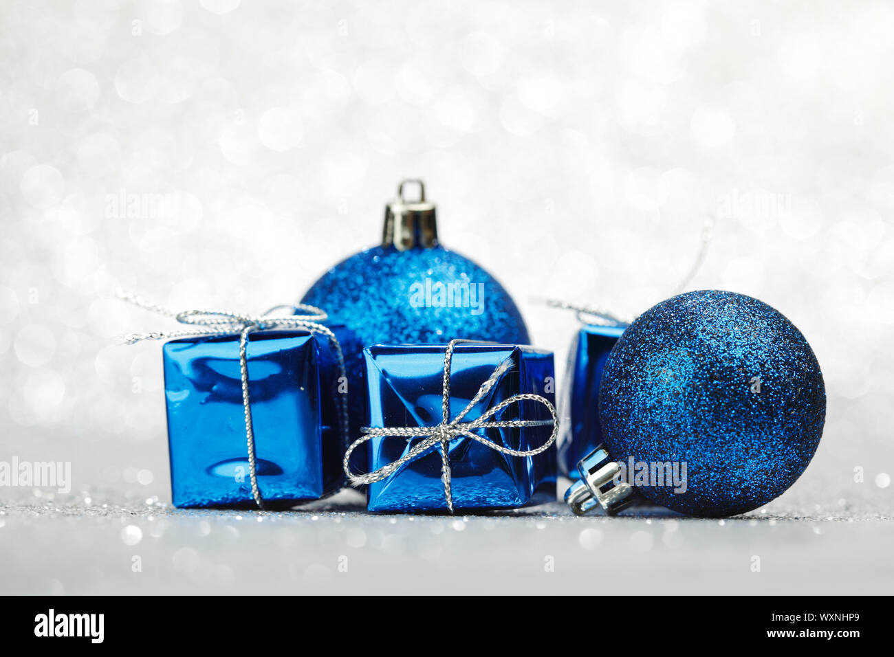 Blue Christmas gift boxes and balls on shiny silver background Stock Photo Alamy