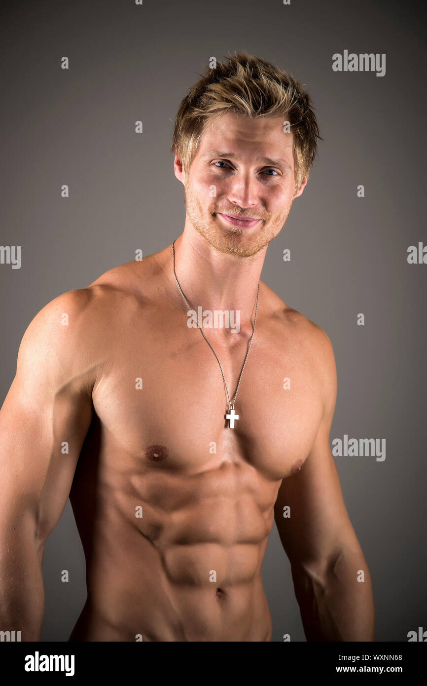 Handsome blond young man exercising pecs on gym equipment Fleece