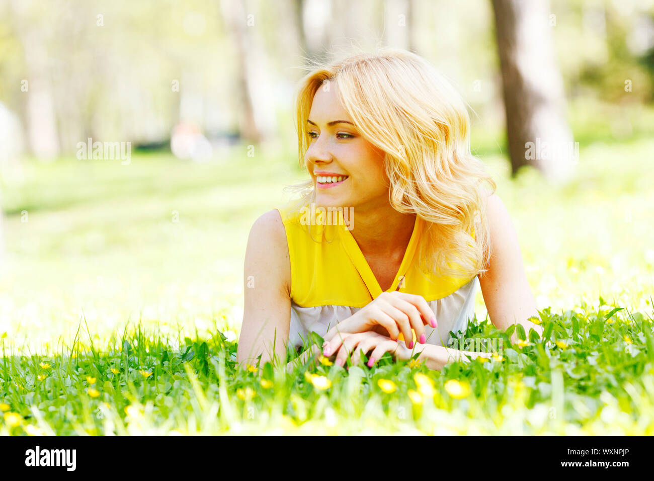 Happy young woman lying on grass Stock Photo - Alamy