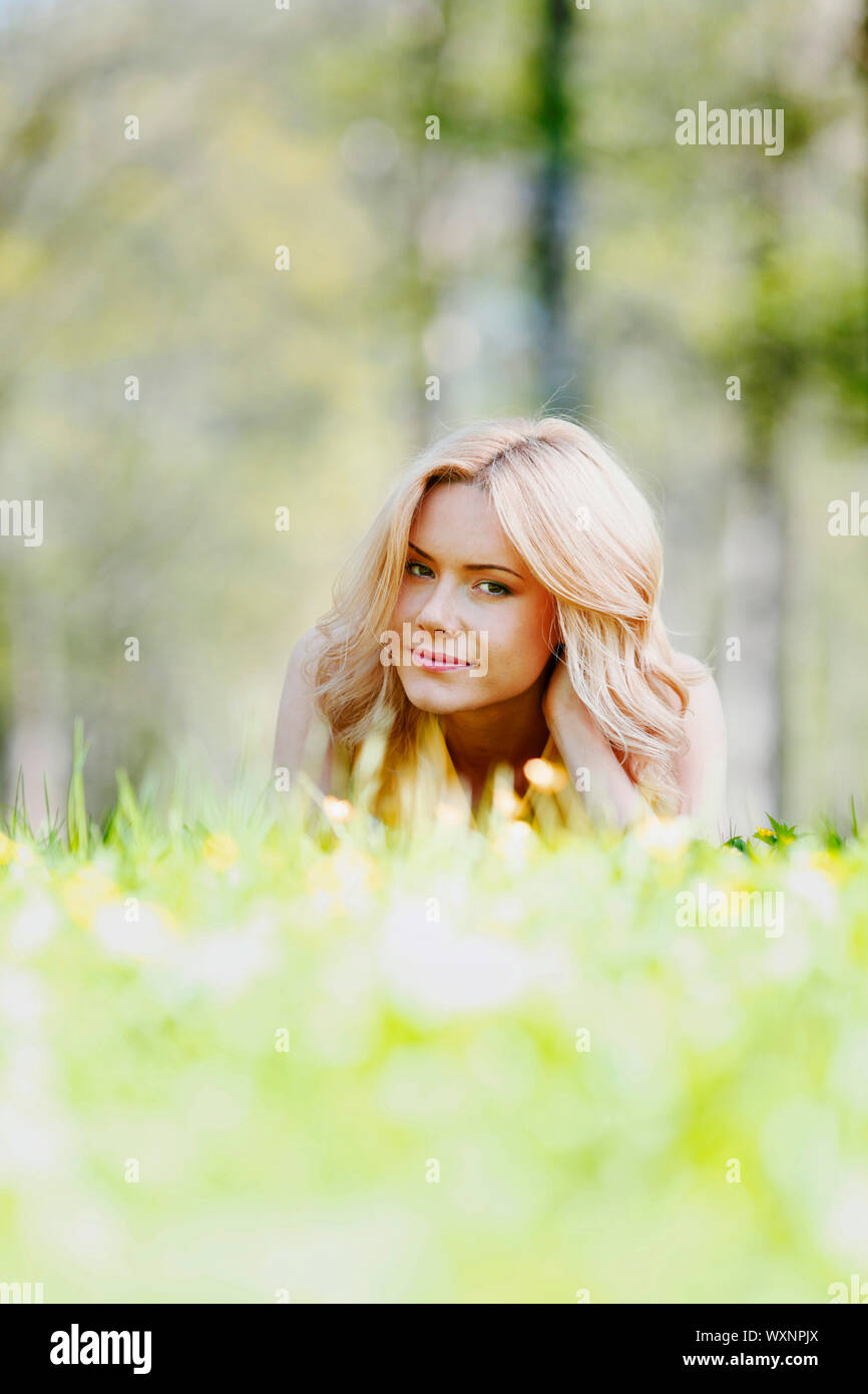 Happy young woman lying on grass Stock Photo - Alamy